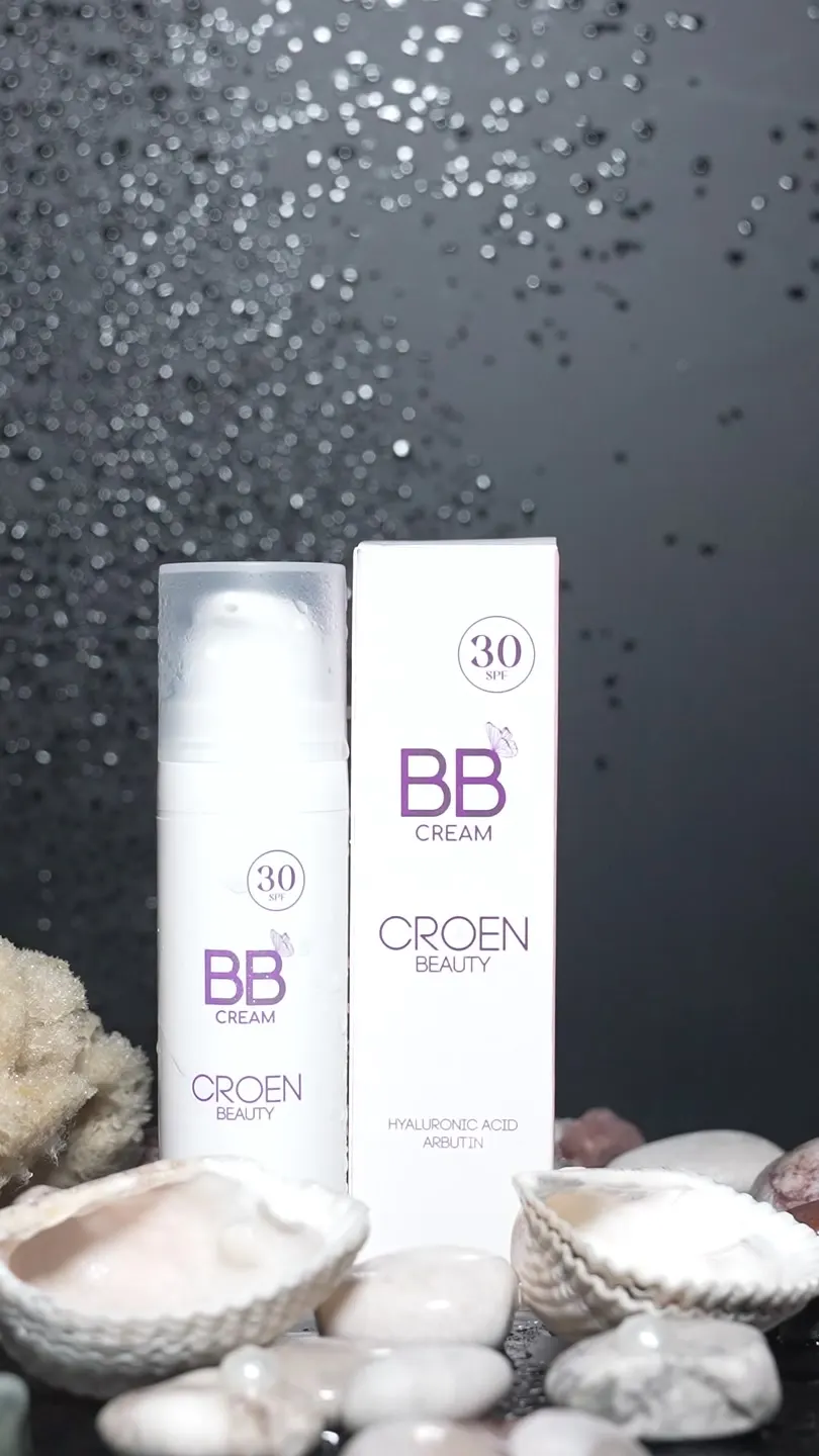 Croen BB Krem SPF 30 şişesi ve kutusu, deniz kabukları ve taşlar arasında